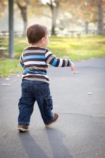 Happy young baby boy walking in the park
