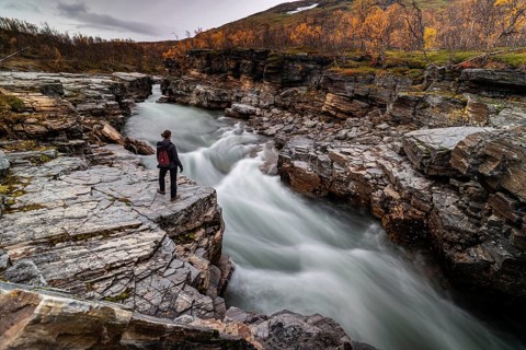 Woman standing at Abiskojakka canyon and river