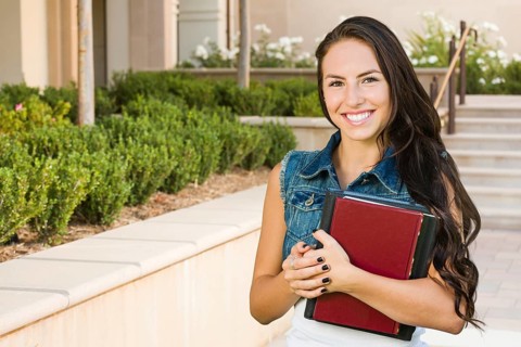 mixed-race young girl student with school books on campus