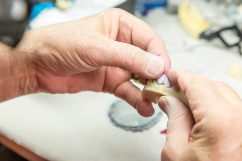 Male dental technician working on A 3D printed mold for tooth implants in the lab