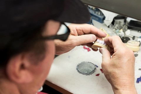 Male dental technician working on A 3D printed mold for tooth implants in the lab