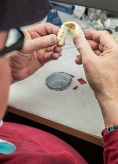 Male dental technician working on A 3D printed mold for tooth implants in the lab
