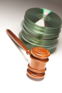 Stack of CD rom or DVD discs and gavel on a gradated background