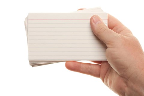 Male hand holding stack of flash cards isolated on a white background