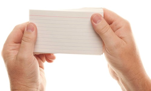 Male hand holding stack of flash cards isolated on a white background