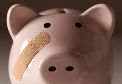 Piggy bank with bandage on face on gradated background