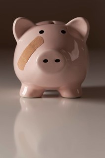Piggy bank with bandage on face on gradated background