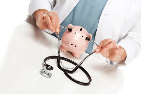 Female doctor holding stethoscope to the ears of A pink piggy bank abstract