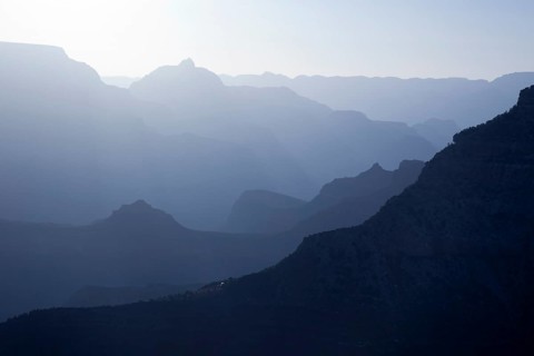 Scenic layers of the grand canyon in the early morning with hikers cabin roof shining in the lower middle