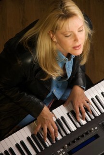 Female musician sings while playing digital piano