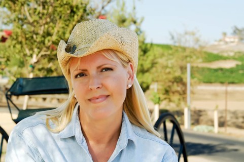 Cute cowgirl in the country wearing cowboy hat