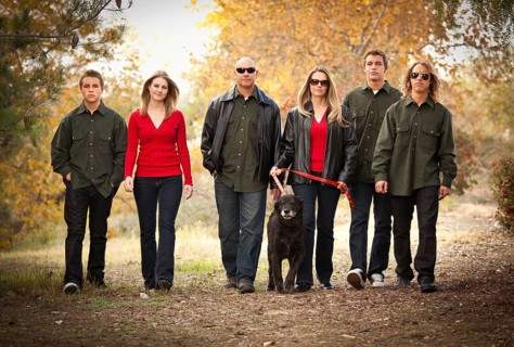 Attractive family portrait walking outdoors with their dog