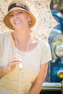 Beautiful 1920s dressed girl with parasol near vintage car portrait