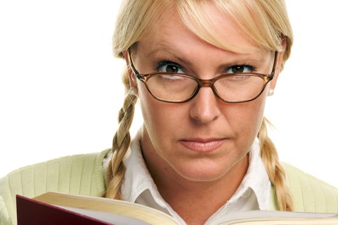 Serious female with ponytails and book isolated on a white background