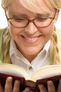 Female with ponytails reads her book isolated on a white background