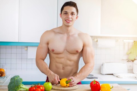 Preparing food cutting vegetables young man lunch in the kitchen healthy nutrition text free space in germany