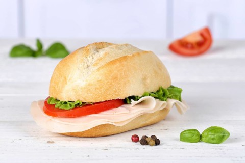 Roll Sandwich Baguette topped with ham on wooden board in Germany