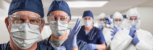 Team of female and male doctors or nurses wearing personal protective equiment in hospital hallway