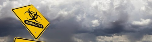 Bio-hazard symbol with sars-cov-2 coronaravirus yellow road sign against ominous stormy cloudy sky