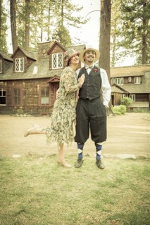Attractive 1920s dressed romantic couple in front of old cabin portrait