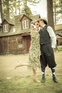 Attractive 1920s dressed romantic couple in front of old cabin portrait