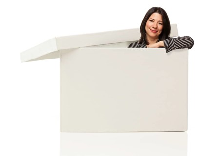 Pretty multiethnic woman standing inside blank white box isolated on a white background