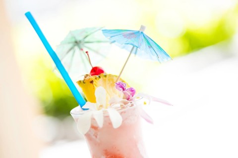 Fruity tropical drink with pineapple and umbrellas at the bar