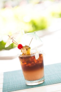 Ice cold mai tai cocktail drink with fruit and umbrellas at the bar