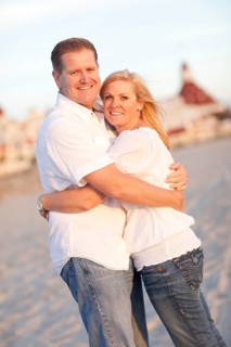 Attractive caucasian couple hugging at the beach in front of the hotel del coronado