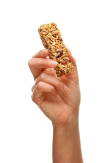 Woman holding granola bar isolated on a white background