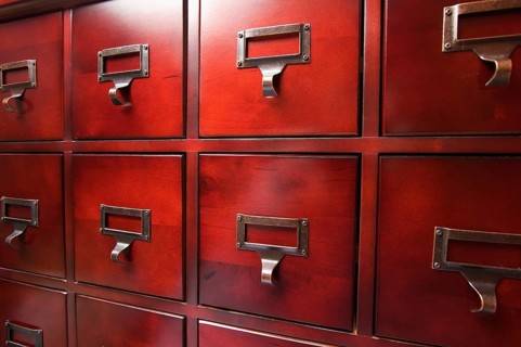 Lustrous wooden card file cabinet in dramatic light