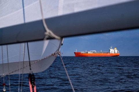 Sailing on the North Sea near Holland with freighter at anchor