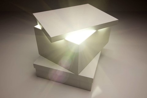 White box with lid revealing something very bright on a grey background
