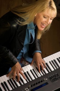 Female musician sings while playing digital piano
