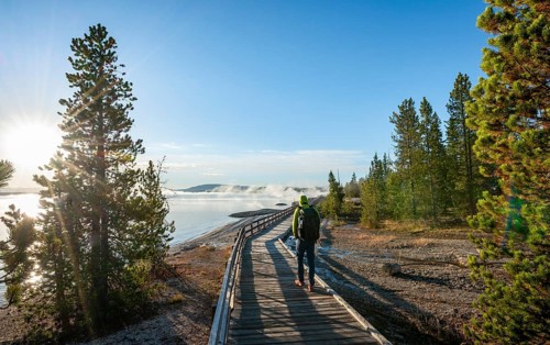 Hiker on boardwalk on the shore of the West Thumb of Yellowstone Lake