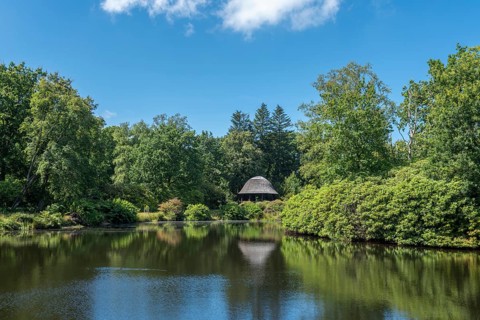 Lake with pavilion in landscape garden and castle park