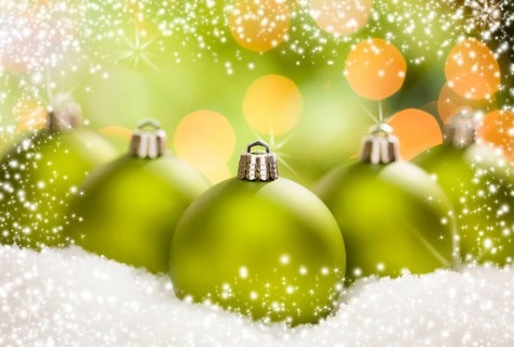 Beautiful matt green christmas ornaments on snow flakes over an abstract snow and light background with room for your own text