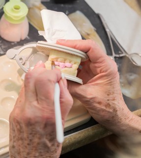 Female dental technician applying porcelain to A 3D printed implant mold in the lab