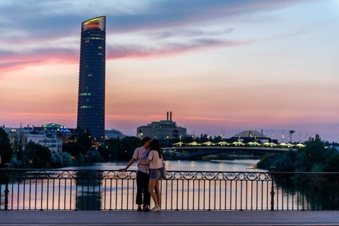 Couple standing on the bridge at sunset and kissing