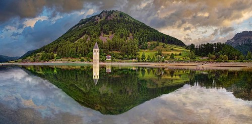 Church tower in the Reschensee with reflection
