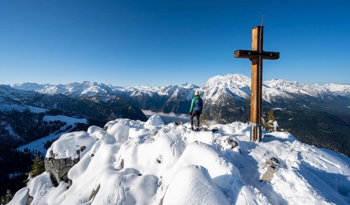 Hiker at the summit of the Jenner with summit cross