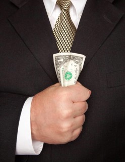 Businessman with coat and tie squeezing dollar bill