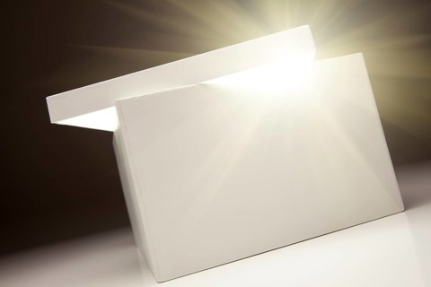 White box with lid revealing something very bright on a grey background