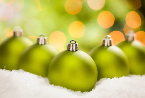 Beautiful matt green christmas ornaments on snow flakes over an abstract background with room for your own text