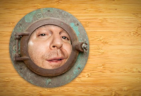 Antique porthole on bamboo wall with funky man looking through the window