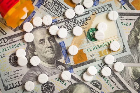 Medicine pills scattered on newly designed U.S. one hundred dollar bills