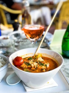 Asian soup in coconut sauce with shrimp and fish with rice