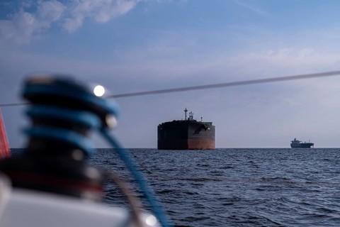 Sailing on the North Sea near Holland with freighter at anchor