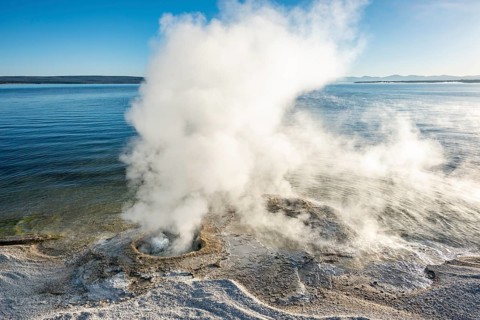 Steaming fumarole at the lake with morning sun