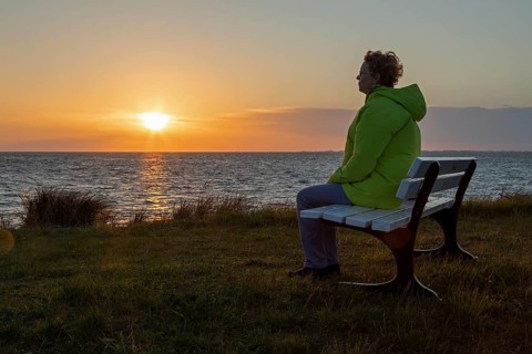 Woman enjoying the sunset on a bench